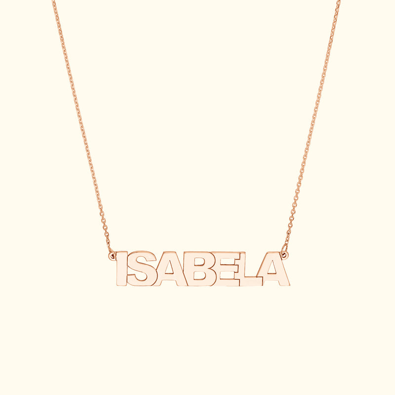 Rose gold name necklace spelling "ISABELA" on a delicate chain.