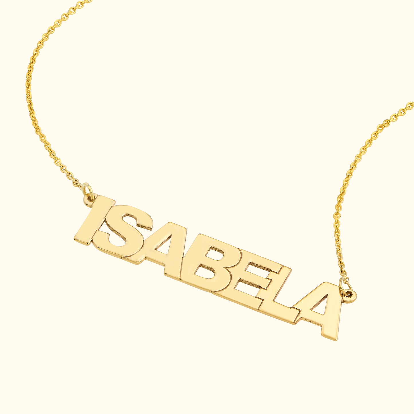 Gold name necklace featuring the word "ISABELA" in bold, uppercase letters.