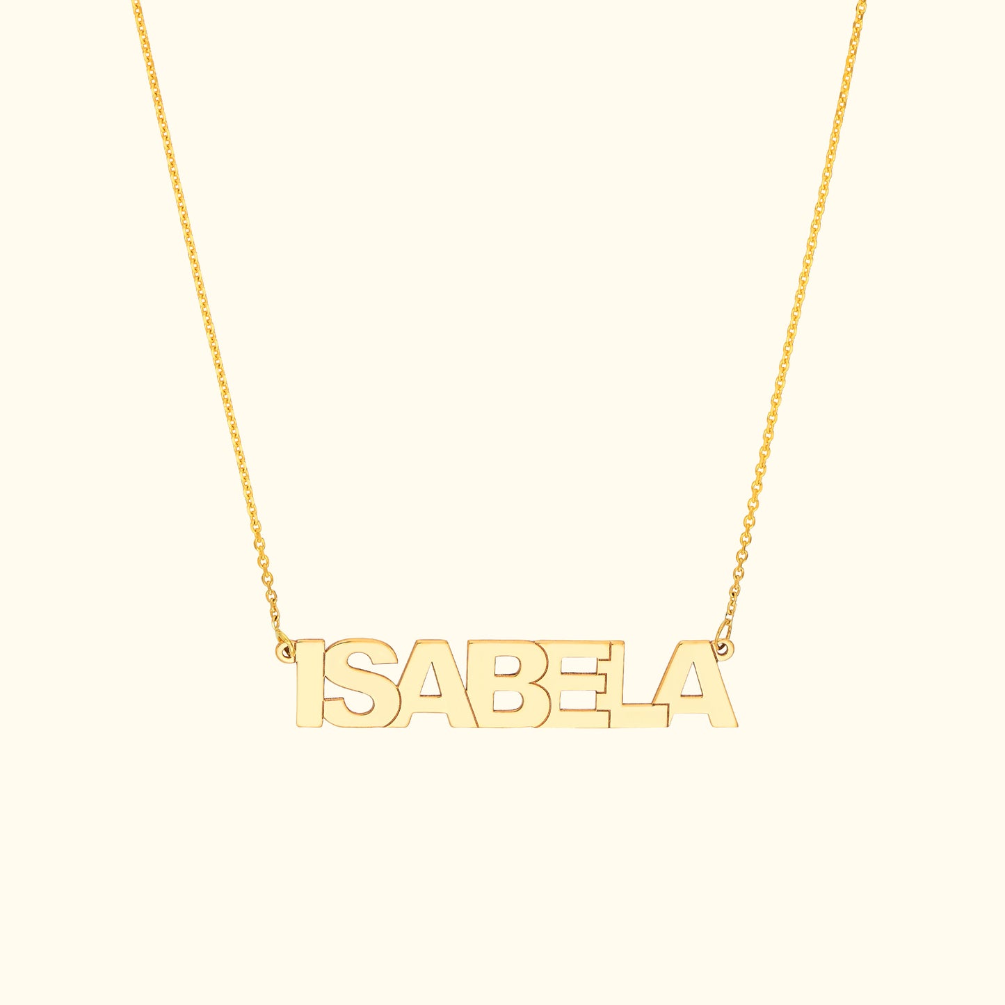 Gold name necklace spelling "ISABELA" on a delicate chain.