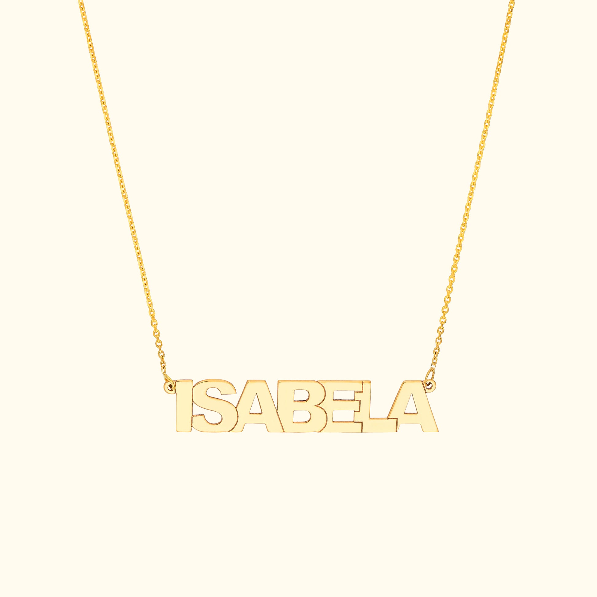 Gold name necklace spelling "ISABELA" on a delicate chain.