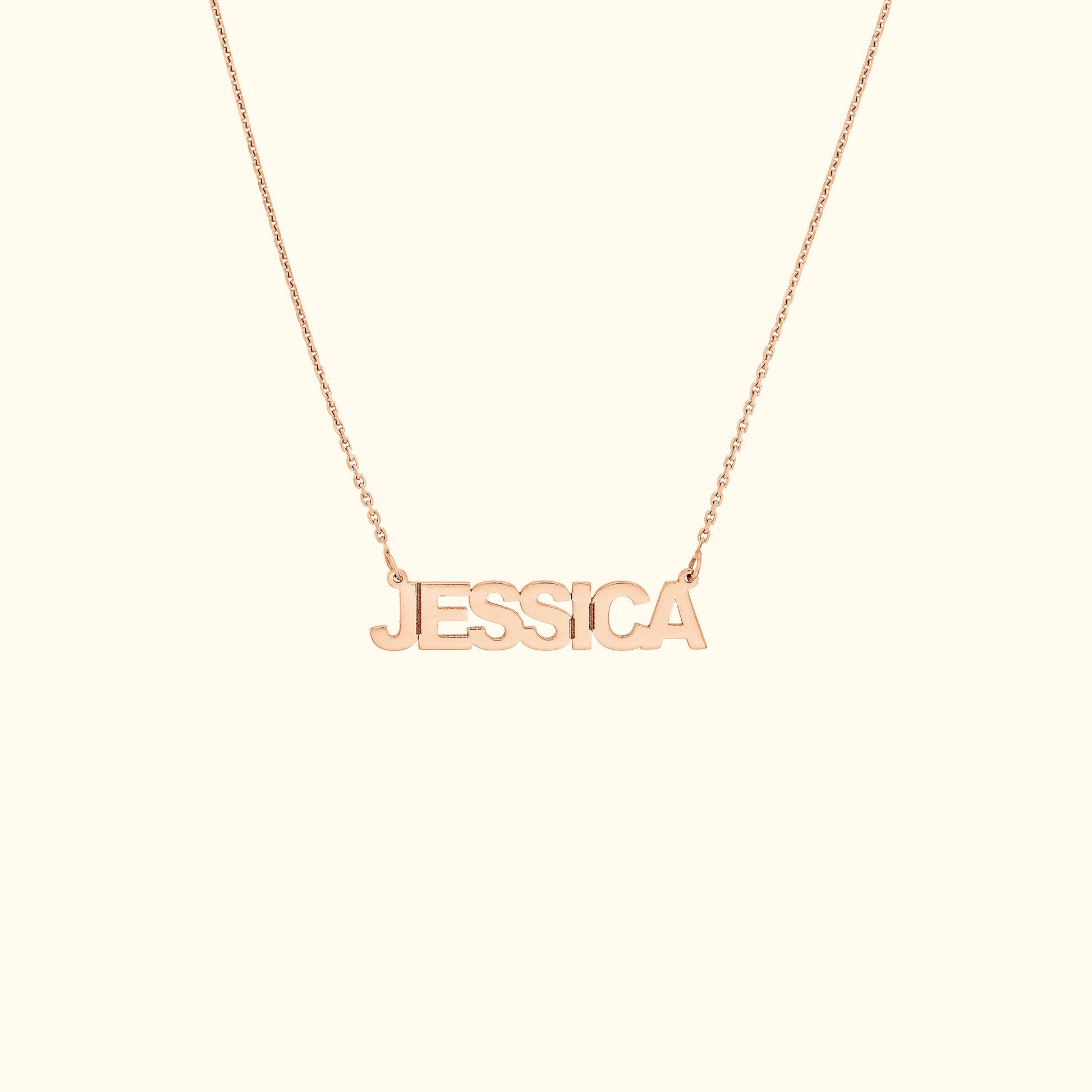 Rose gold name necklace displaying the name "JESSICA" in block letters.