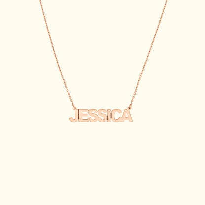 Rose gold name necklace displaying the name "JESSICA" in block letters.