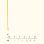 Thin gold chain necklace with a clasp, displayed alongside a ruler for size reference.