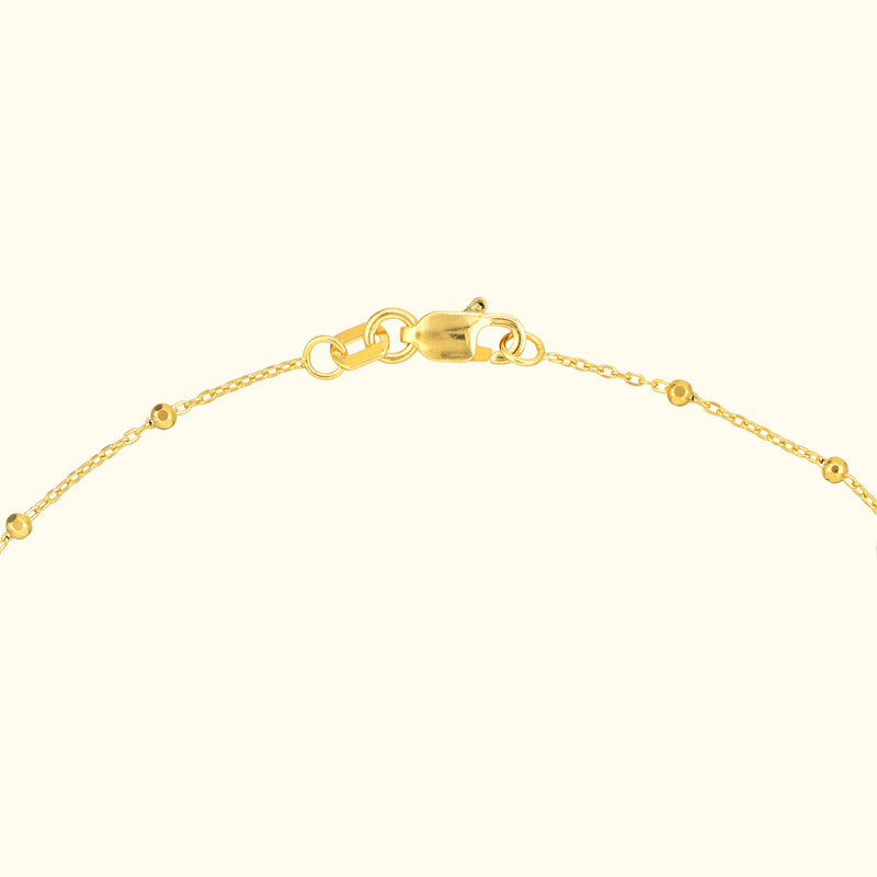 Delicate gold chain bracelet with a clasp, featuring small round embellishments.