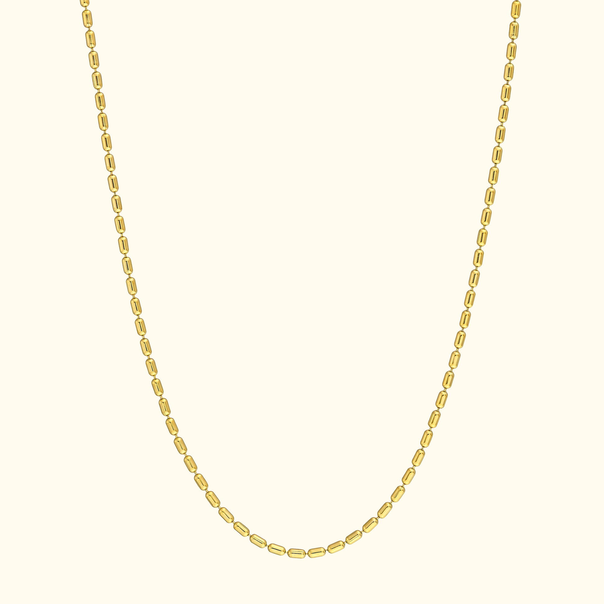 Simple gold chain necklace with oval links against a light background.