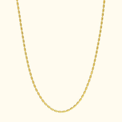 Simple gold chain necklace with oval links against a light background.