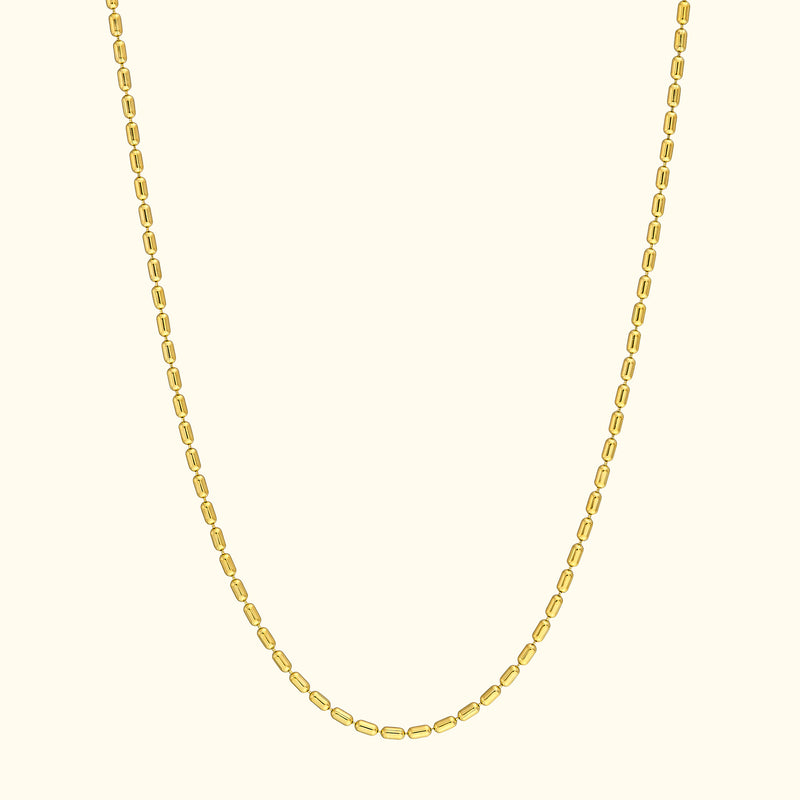Simple gold chain necklace with oval links against a light background.