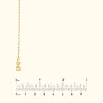 Thin gold chain necklace with a lobster clasp against a light background.