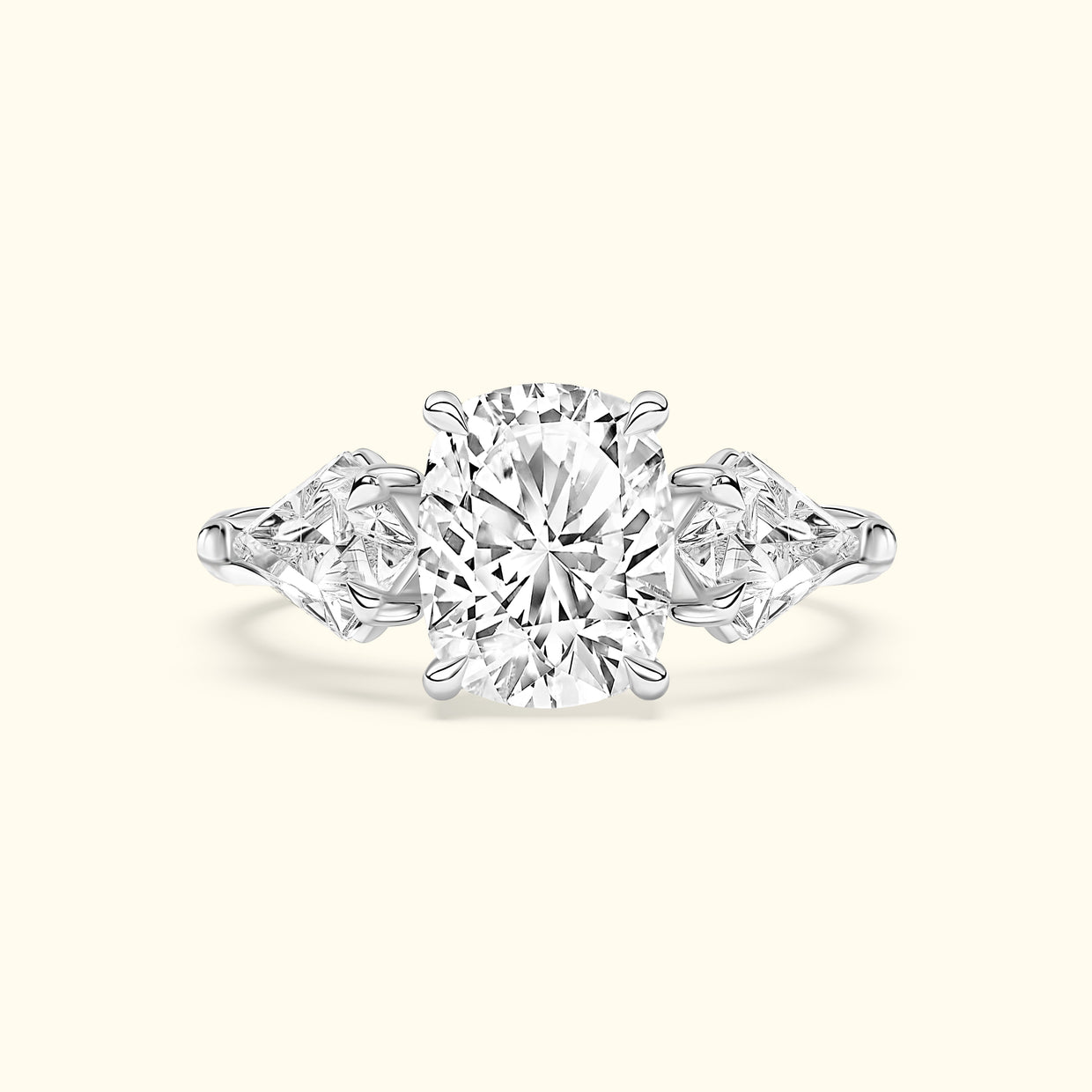 A three-stone engagement ring with an oval central diamond and two triangular side diamonds.