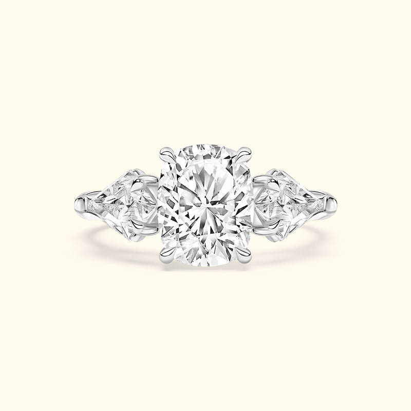 A three-stone engagement ring with an oval central diamond and two triangular side diamonds.