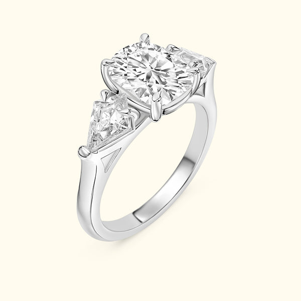 Three-stone diamond ring featuring a large round center stone and two triangular side stones.