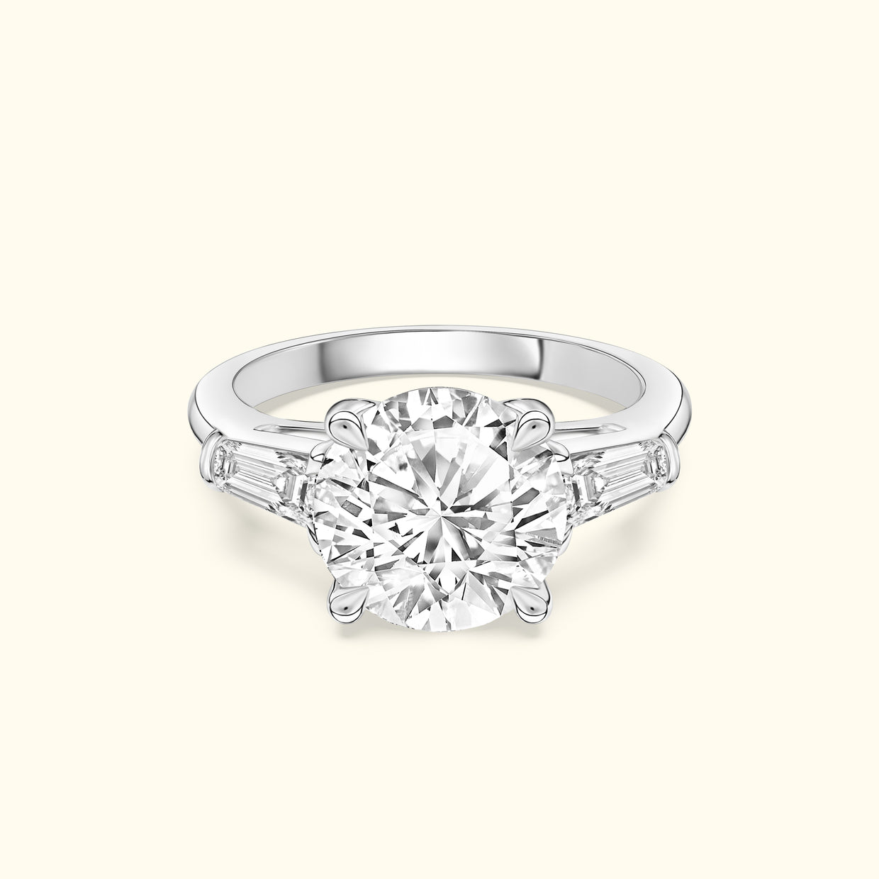 Three-stone engagement ring featuring a large round diamond center and tapered side stones.