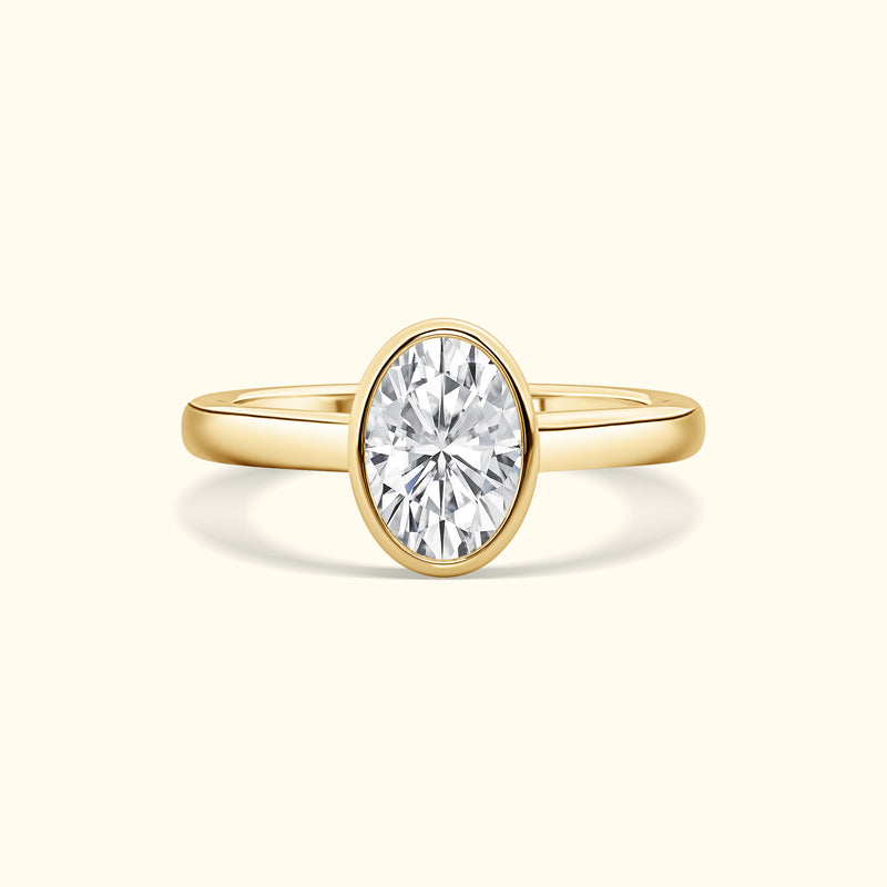 Gold band ring featuring a large oval diamond at the center.