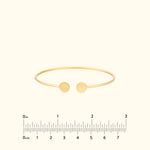 Minimalist gold cuff bracelet with two circular ends.