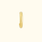 Gold hoop earring with a sleek, smooth design on a light background.