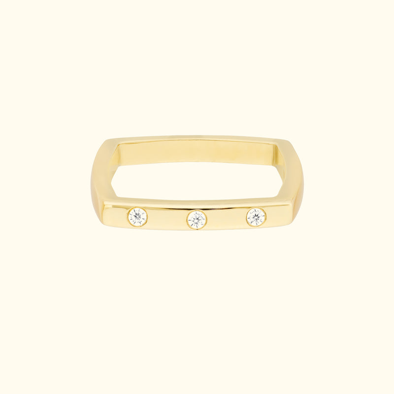 Gold rectangular ring featuring three small, sparkling diamonds.