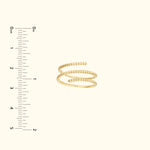 Gold spiral ring displayed next to a ruler for size reference.