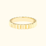 Textured gold ring with a serrated edge design.