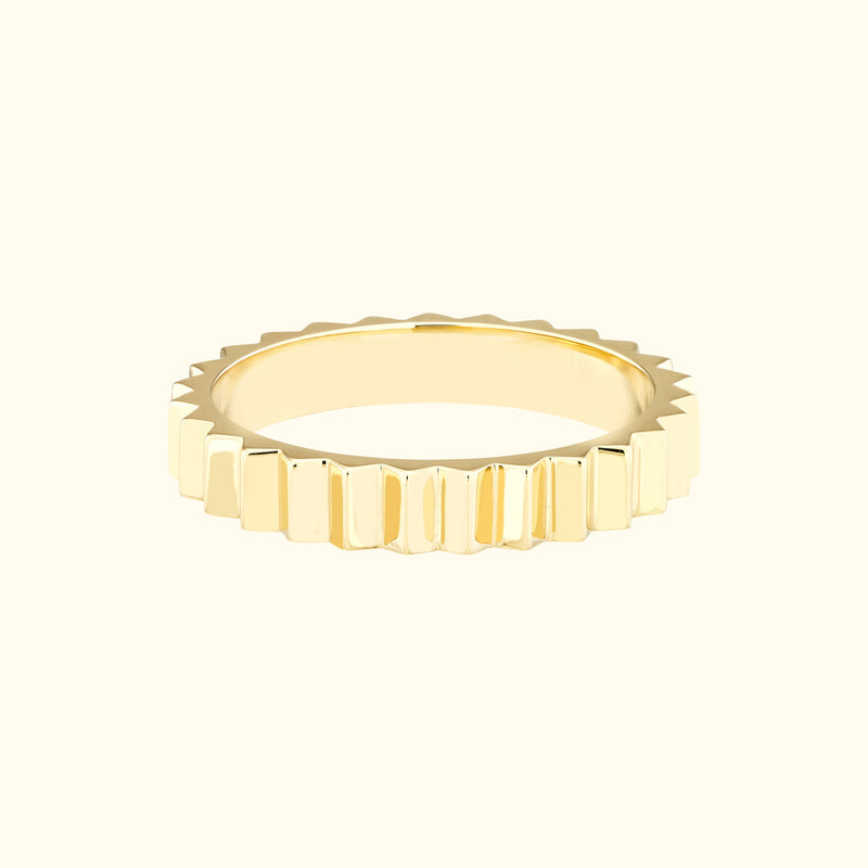 Textured gold ring with a serrated edge design.