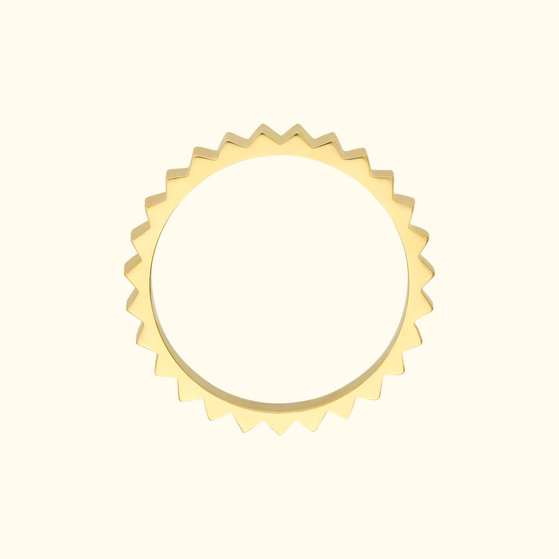 Yellow gold band with a zigzag edge design set against a light background.