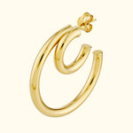Polished gold hoop earrings with a curved design, showcasing a modern style.
