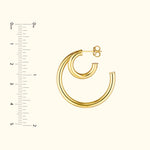 Gold hoop earrings in two sizes, displayed against a light background with a ruler for scale.