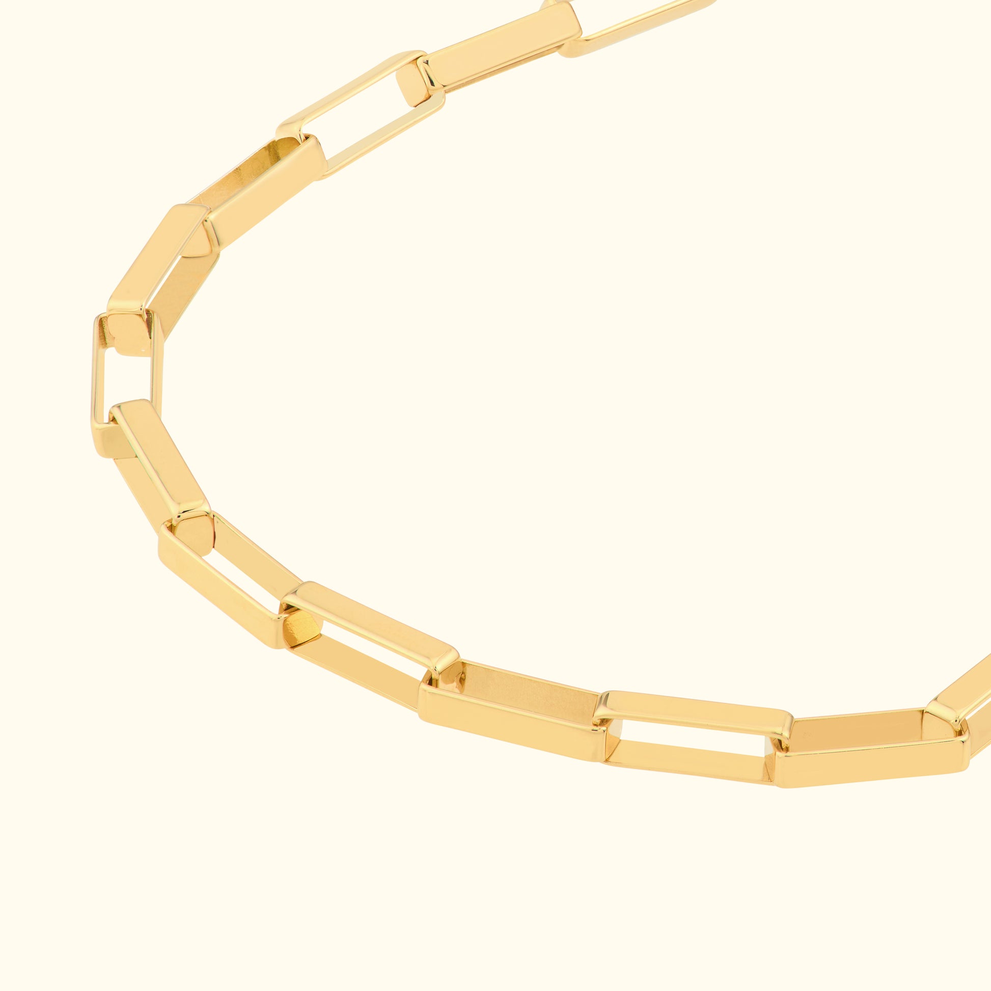 Gold chain necklace with rectangular links against a light background.