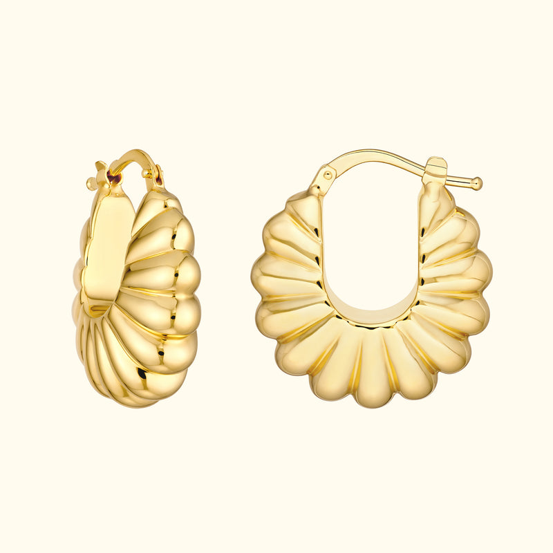 Curved golden hoop earrings with a scalloped design.