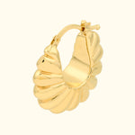 Gold spiral hoop earring with a textured shell design.