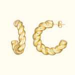 Golden twisted hoop earrings displayed against a light background.
