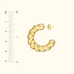 Twisted gold hoop earring displayed against a light background with a ruler for size reference.