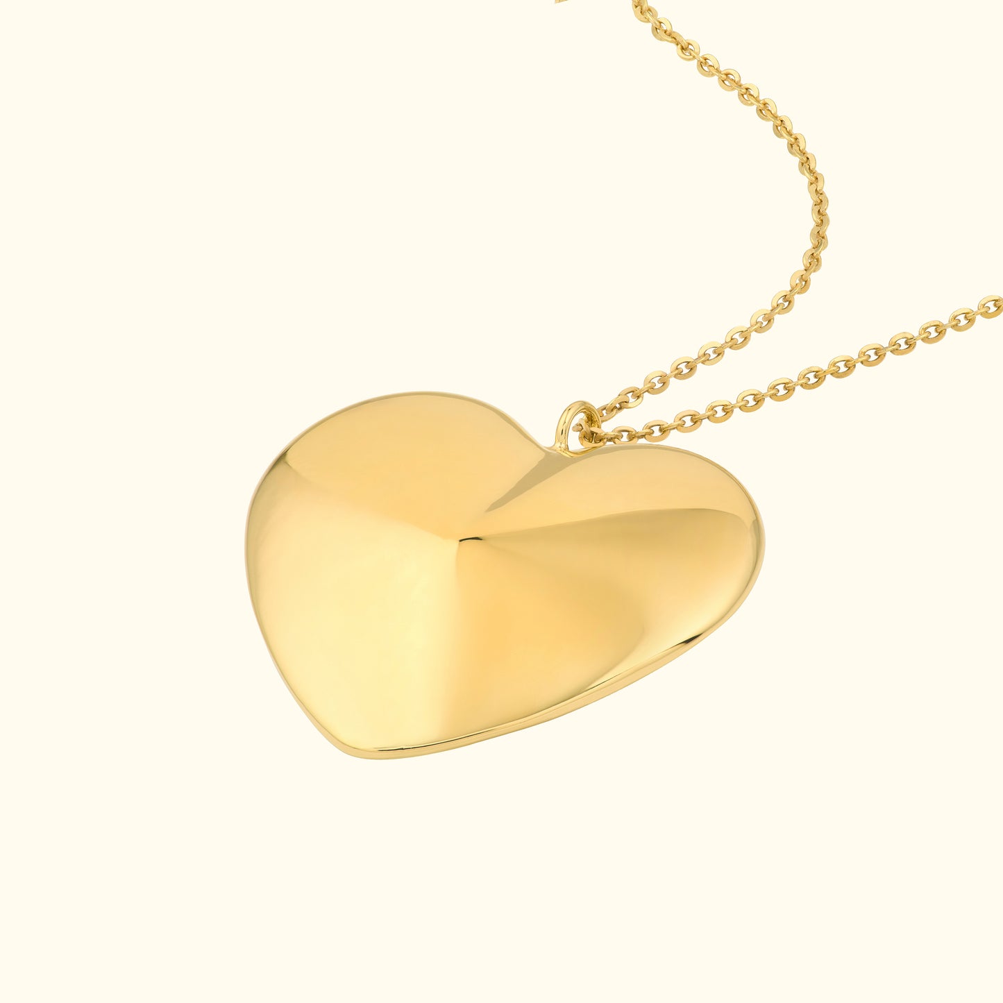 Shiny gold heart pendant hanging from a delicate chain.