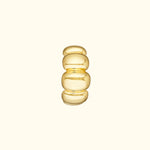 Smooth, stacked gold ring with rounded shapes against a light background.
