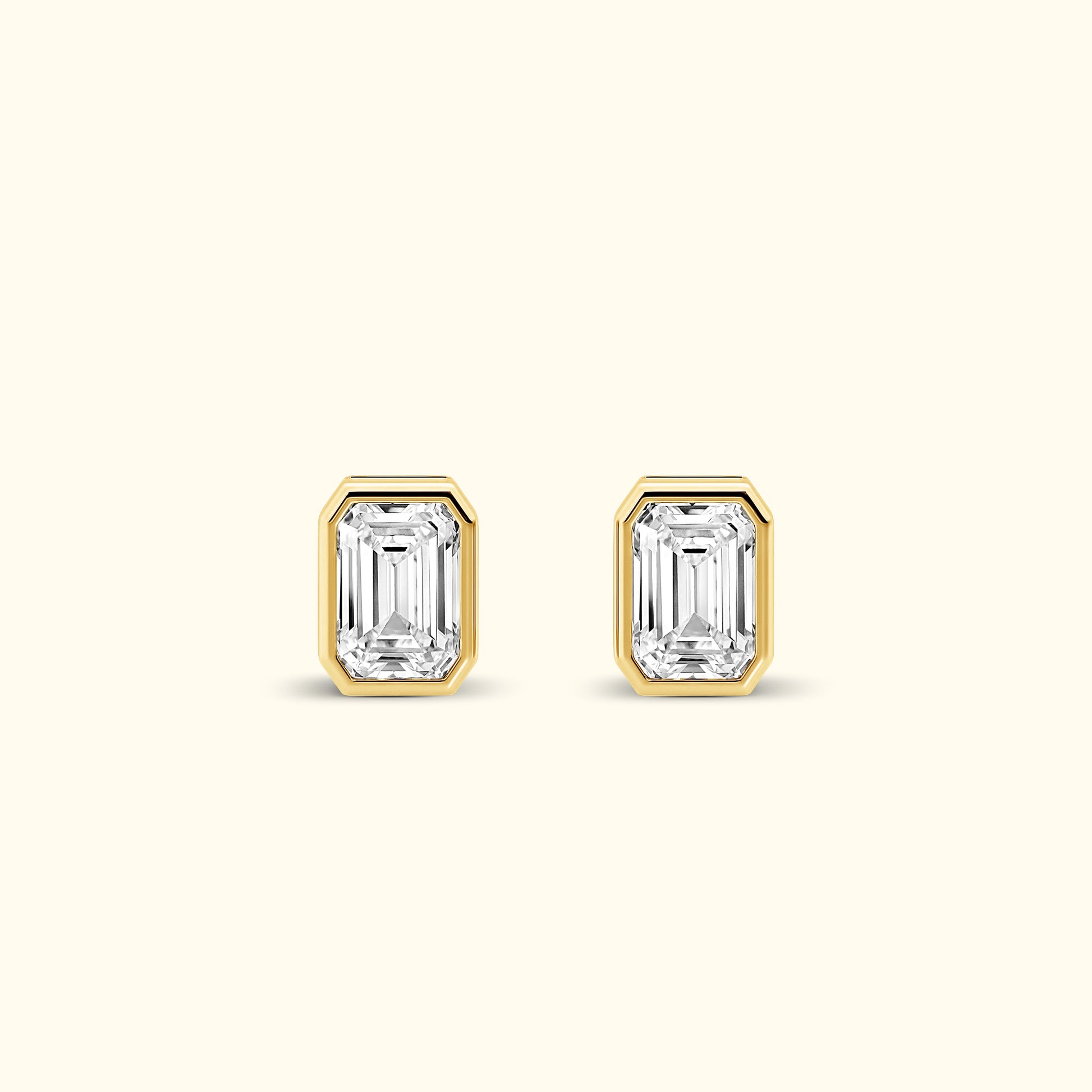 Emerald-cut diamond stud earrings set in gold.