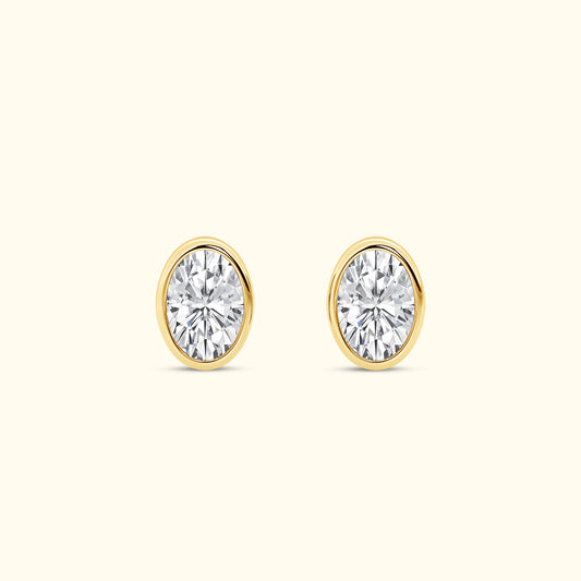 Gold hoop earrings featuring large, oval-cut clear diamonds.