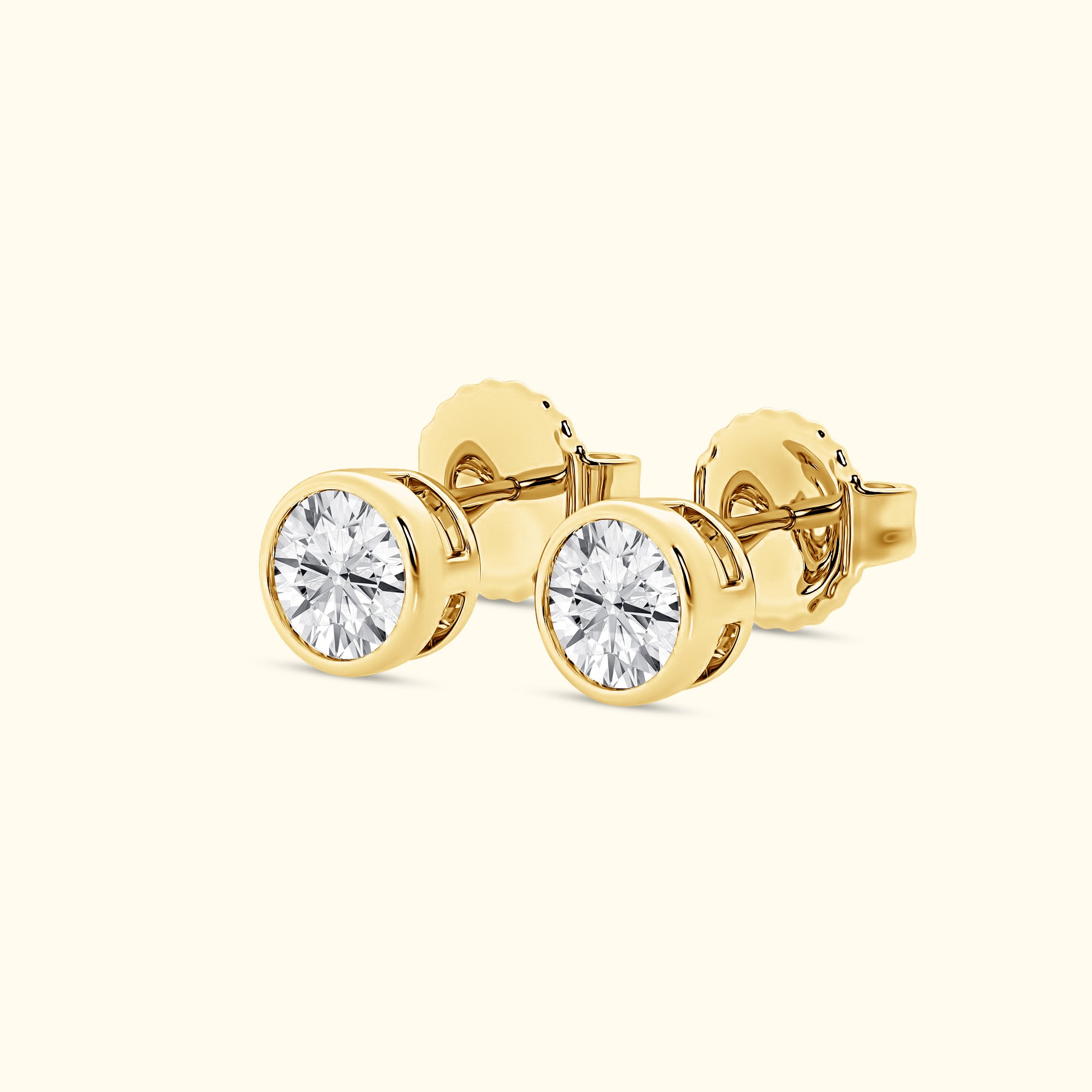 Gold stud earrings featuring round, sparkling clear diamonds.