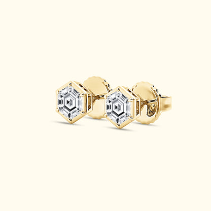 Hexagonal gold earrings with clear, sparkling gemstones.