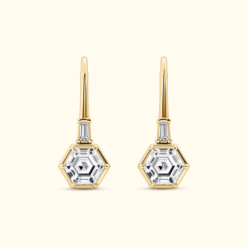 Gold hexagonal drop earrings with clear gemstones, featuring elegant detailing.