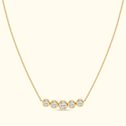 Gold necklace with five round diamonds set in circular settings.