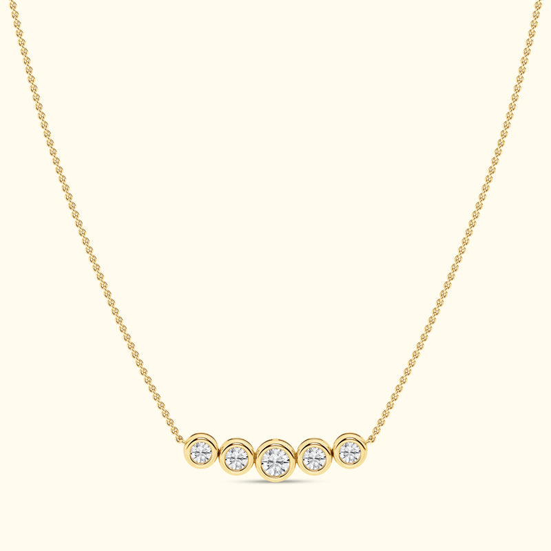 Gold necklace with five round diamonds set in circular settings.