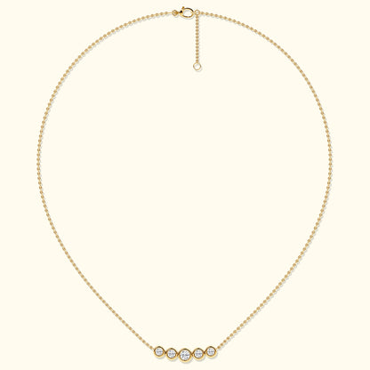 Delicate gold necklace featuring five sparkling diamond-like stones.