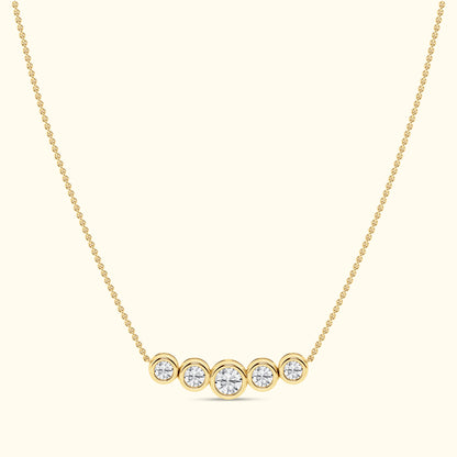 Gold necklace featuring five round diamonds arranged in a horizontal line.