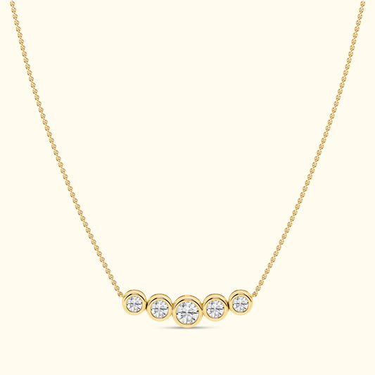 Gold necklace featuring five round diamonds arranged in a horizontal line.