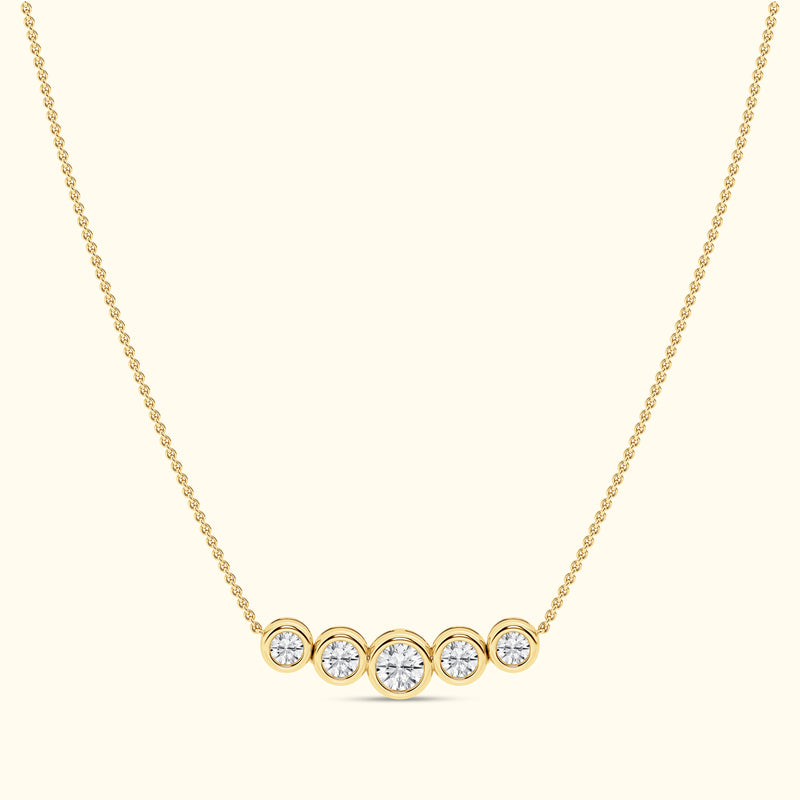 Gold necklace featuring five round diamonds arranged in a horizontal line.