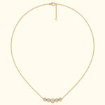 Delicate gold necklace with five sparkling diamonds in circular settings.