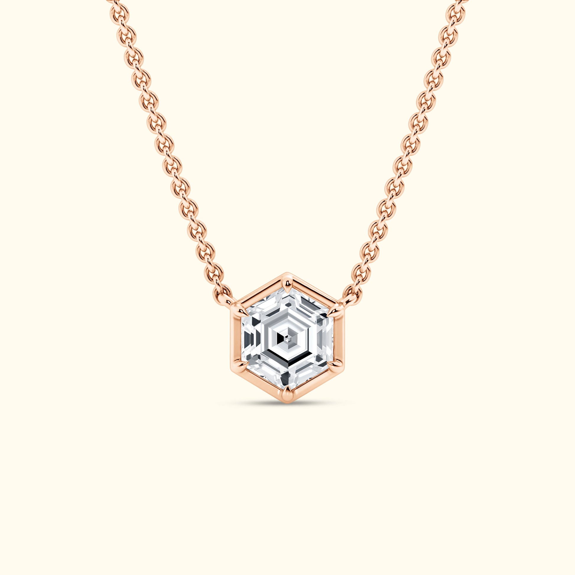 Hexagon-shaped pendant necklace with a clear gemstone on a rose gold chain.