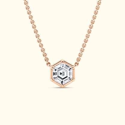 Hexagon-shaped pendant necklace with a clear gemstone on a rose gold chain.