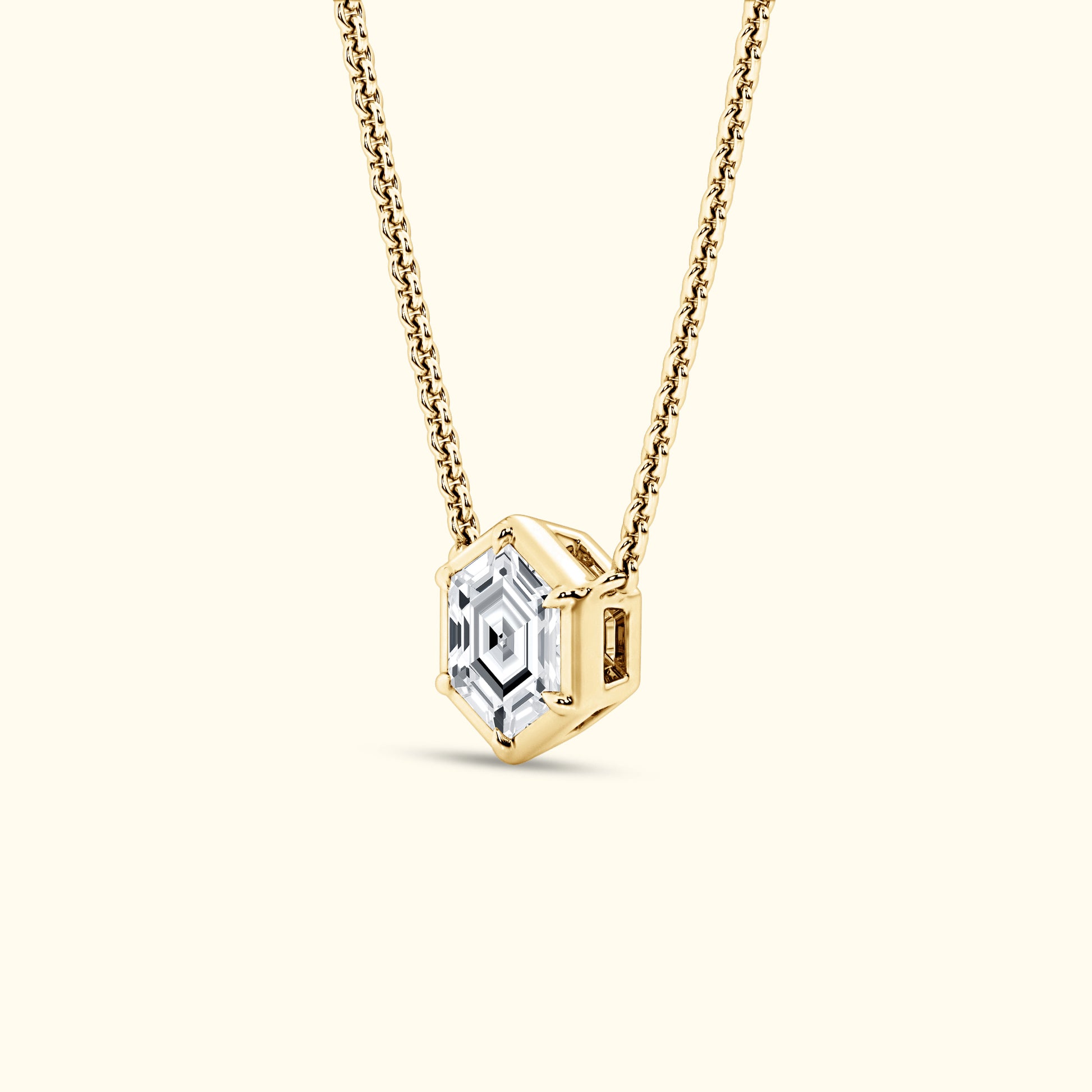 Gold necklace featuring a hexagonal pendant with a clear diamond center.