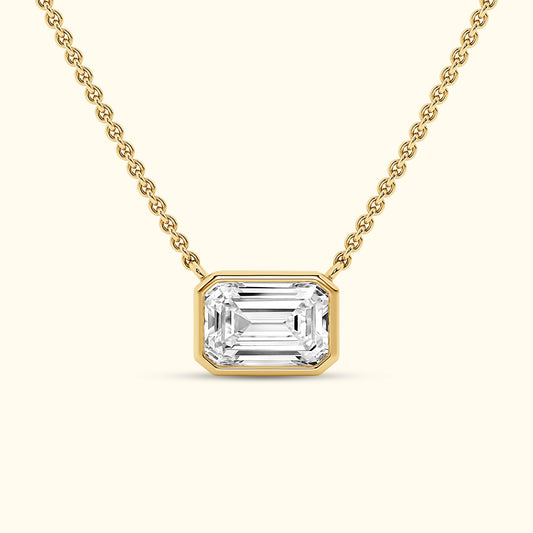 Gold necklace featuring an emerald-cut diamond pendant.