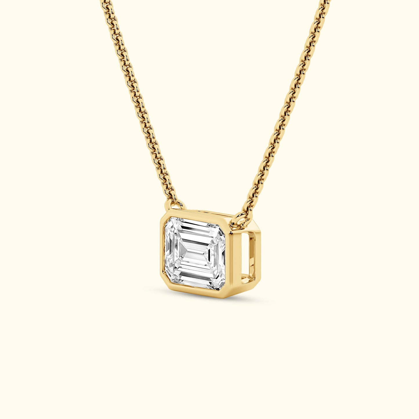 Gold necklace featuring a rectangular diamond pendant on a delicate chain.